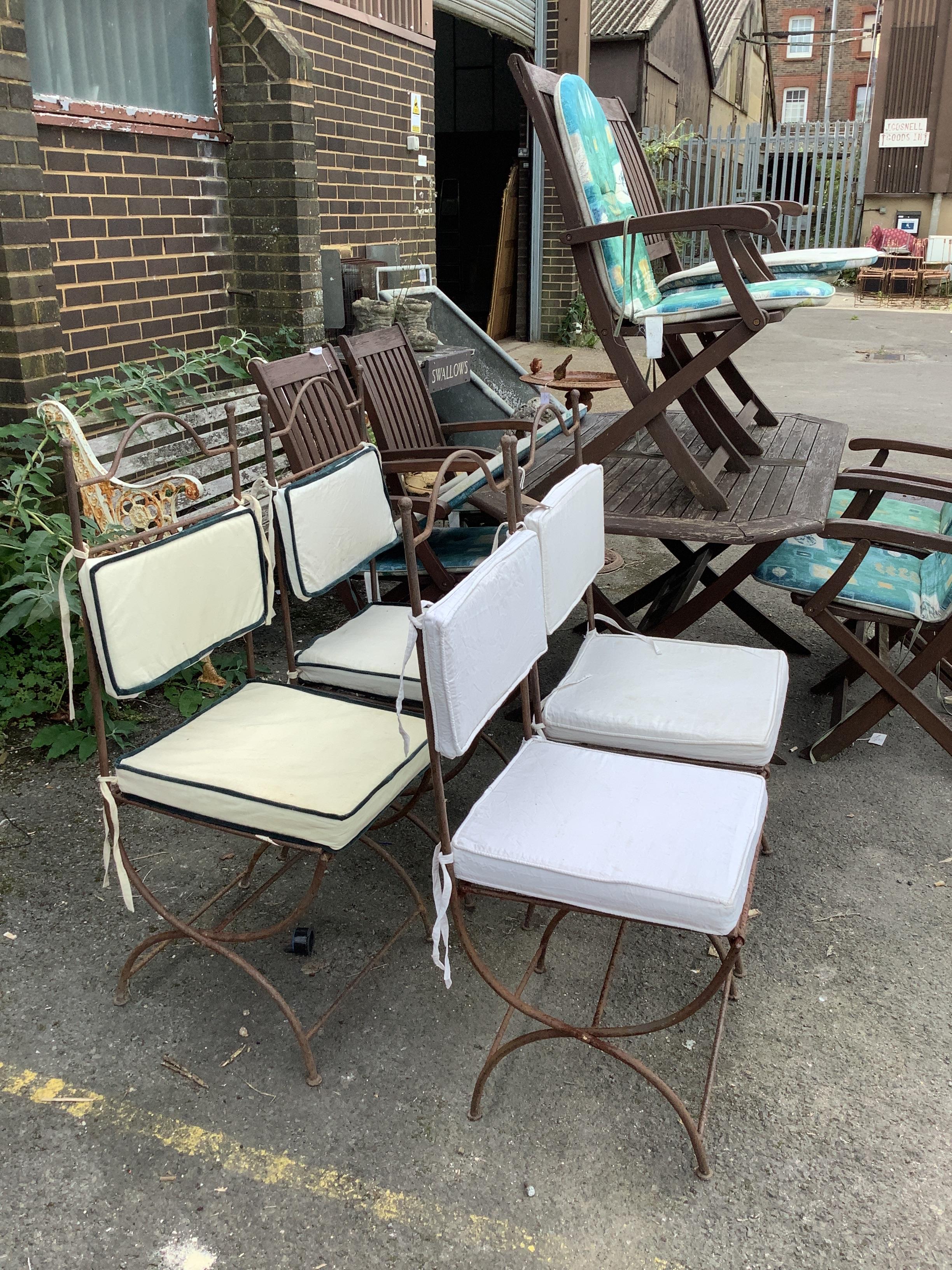 A set of four wrought iron folding garden chairs with seat pads, height 104cm